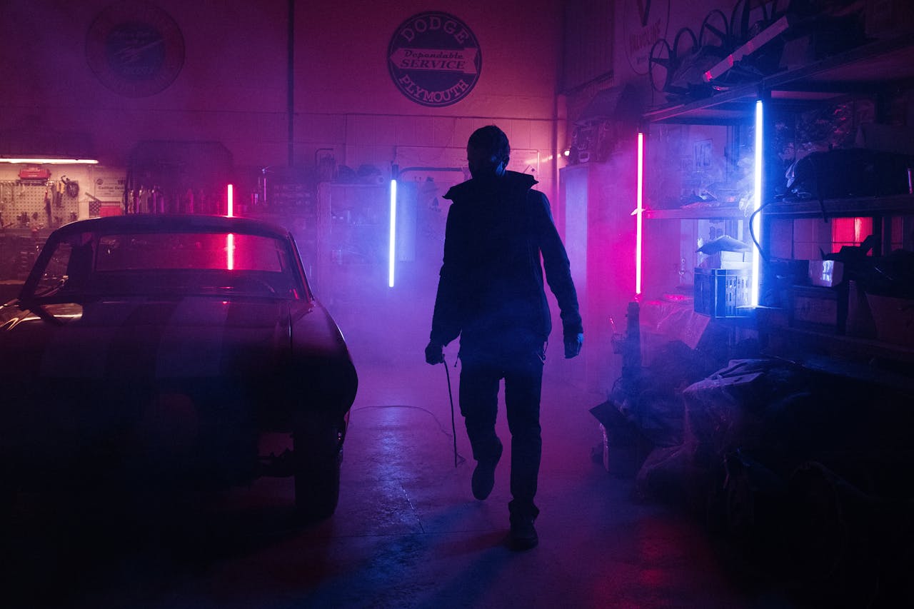 Man in Black Jacket Walking on Sidewalk during Night Time